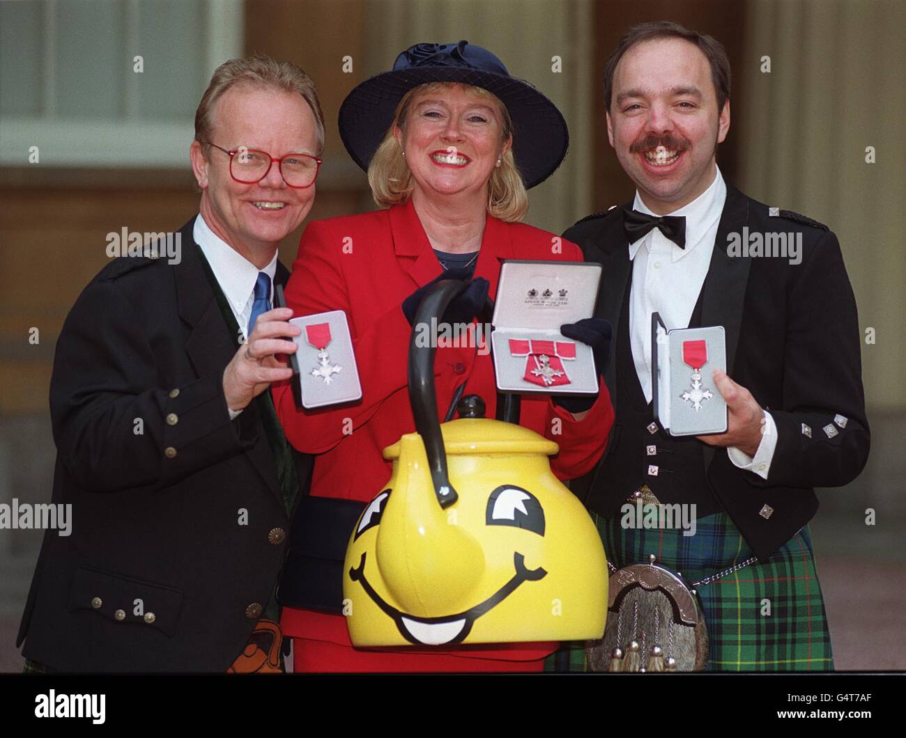 L-R: Artie Trezise, Cilla fisher and Gary Coupland, the three original members of The Singing Kettle, a Scottish children's entertainment troupe, who were presented with MBEs for services to Children's Entertainment at Buckingham Palace, London. Stock Photo