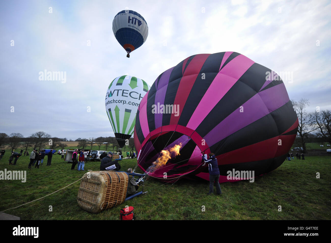 Photo. Crews inflate their hot air balloon using a propane burner as they prepare for flight at the 40th Annual International Icicle Balloon Meet, taking place on the first full weekend in January and attended by pilots and balloon crews from all over the world, gathering in a field near Savernake Forrest, near Marlborough, to take flight across the Wiltshire countryside. Stock Photo