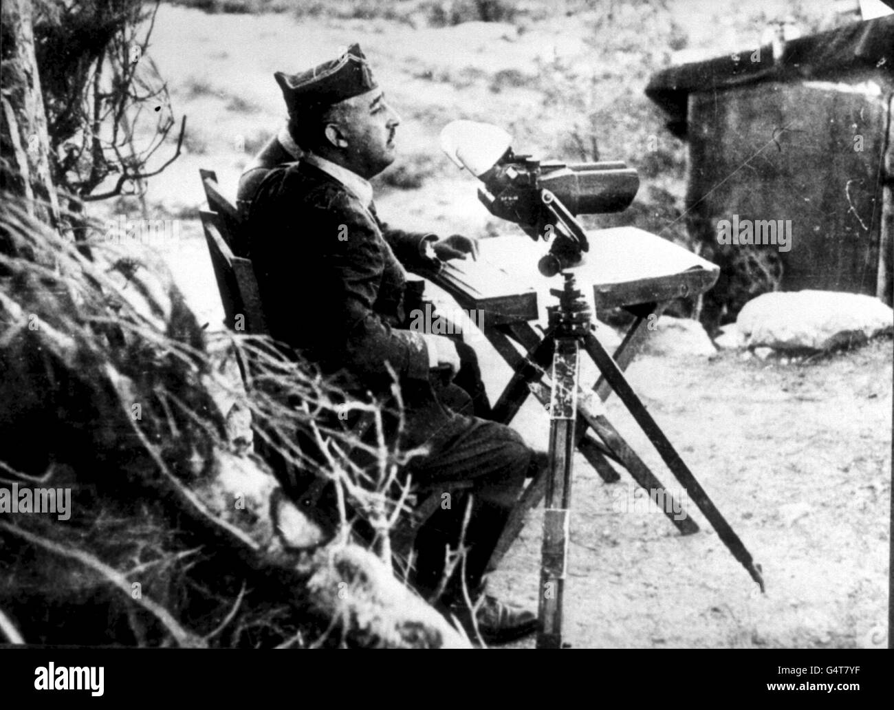 18TH JULY: The Spanish Civil War begins, with General Francisco Franco leading the uprising. c1936: General Francisco Franco, Commander of the Fascist forces in the Spanish Civil War of 1936-1939, seated with binoculars at the Front. Stock Photo
