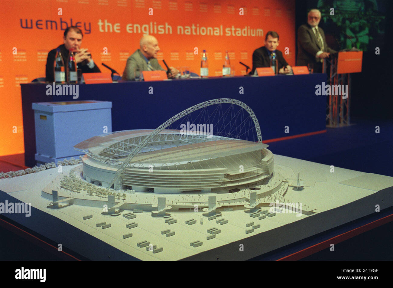 A model of the proposed new look Wembley Stadium unveiled at Wembley in London by Sir Norman Foster (backgorund, centre). A 153 metre-tall steel structure arching directly over the arena will crown the new 475 million national stadium at Wembley. *The unveiling of the arch came as the full planning application for the new 90,000-seat English national stadium, which will receive 120million in Lottery funding, was submitted to the local authority, Brent Council. Stock Photo