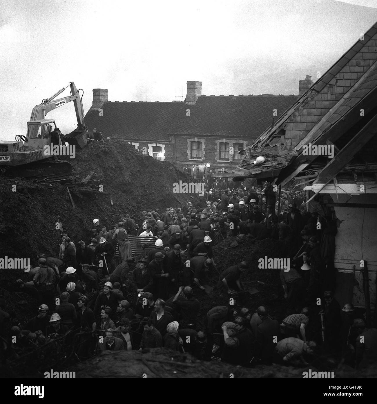 Still toiling at daybreak and after many hours, rescue workers dig in the wreckage of the school engulfed by a sliding mountain of slag at Aberfan, South Wales. Stock Photo