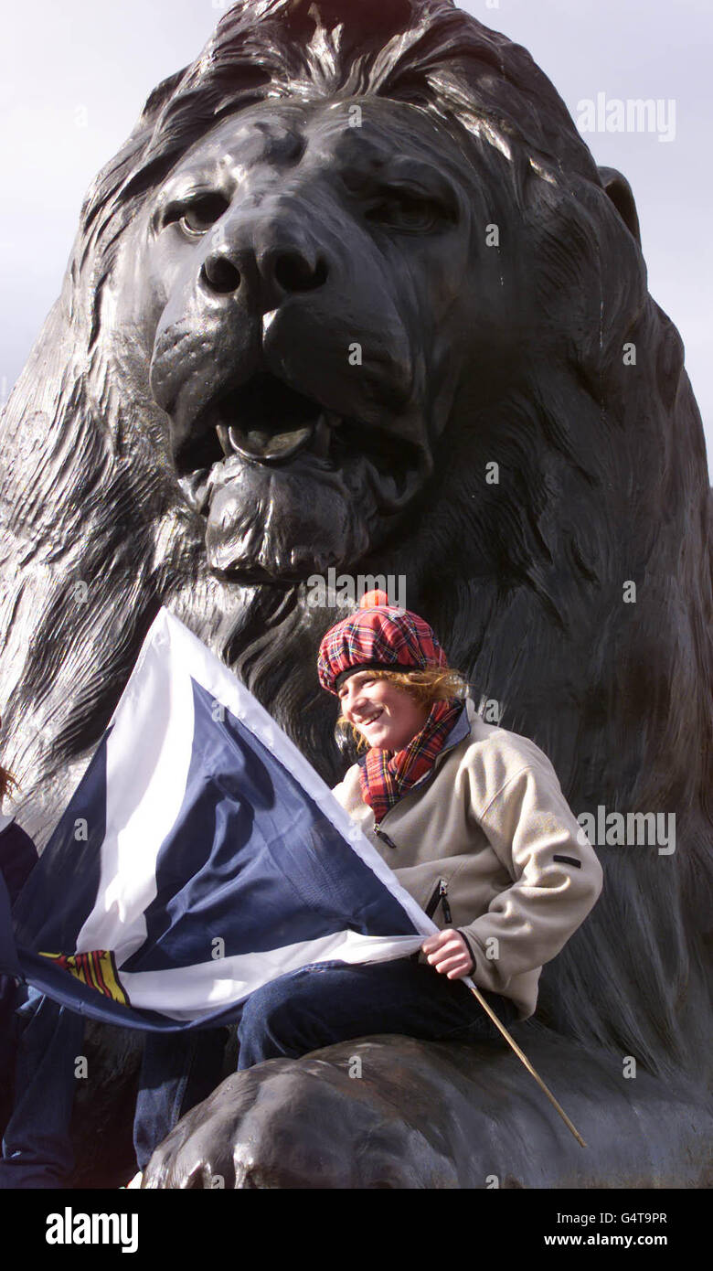 A Scottish fan astride the lion at Nelson's Column in Trafalgar Square in London, ahead of the Euro 2000 play off's between England and Scotland, at Wembley Stadium. Stock Photo