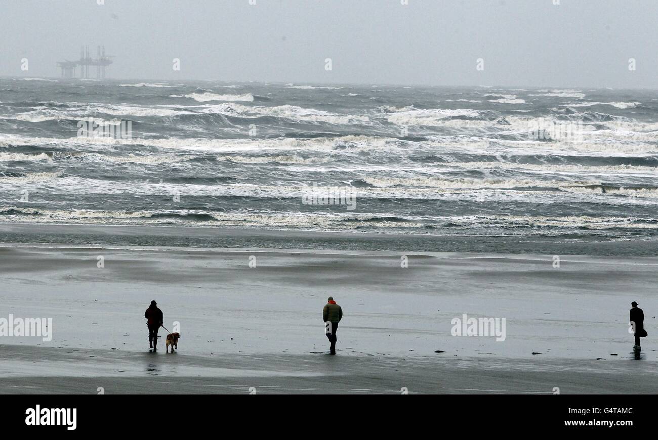 A few people brave the bad weather on Freshfield Beach, Sefton, Merseyside. Stock Photo