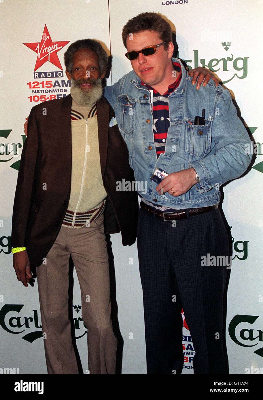 Cedric (left), a regular guest on television's TFI Friday, and Suggs, of the pop group Madness, attending the Virgin Radio/Carlsberg Pre-Christmas party, at Chelsea Bridge Wharf, London. Stock Photo