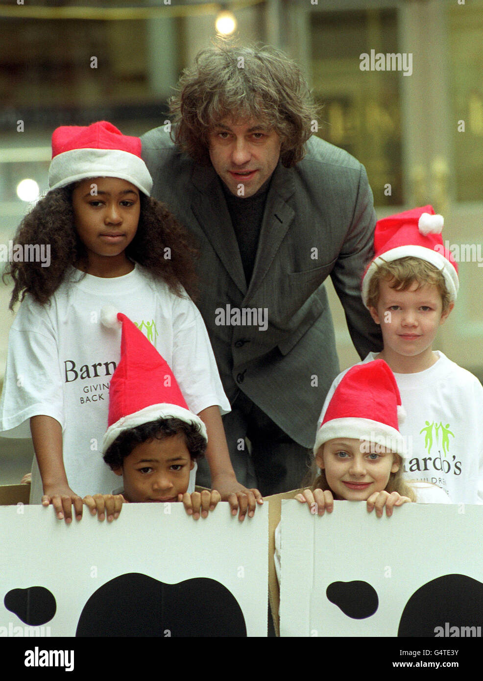 Sir Bob Geldof with some children at the launch of a new scheme by Barnado's, the UK's largest children's charity, and Gateway, a leading computer manufacture. Gateway are donating 25 to the charity for every family style PC sold via it's on-line store. Sir Bob is accomapnied by Sarah Green (standing left), her brother Gino Green,9, (kneeling below), James Cullen, 9,( (standing, right) and Trinity Ileim, 11, (kneeling right). Stock Photo