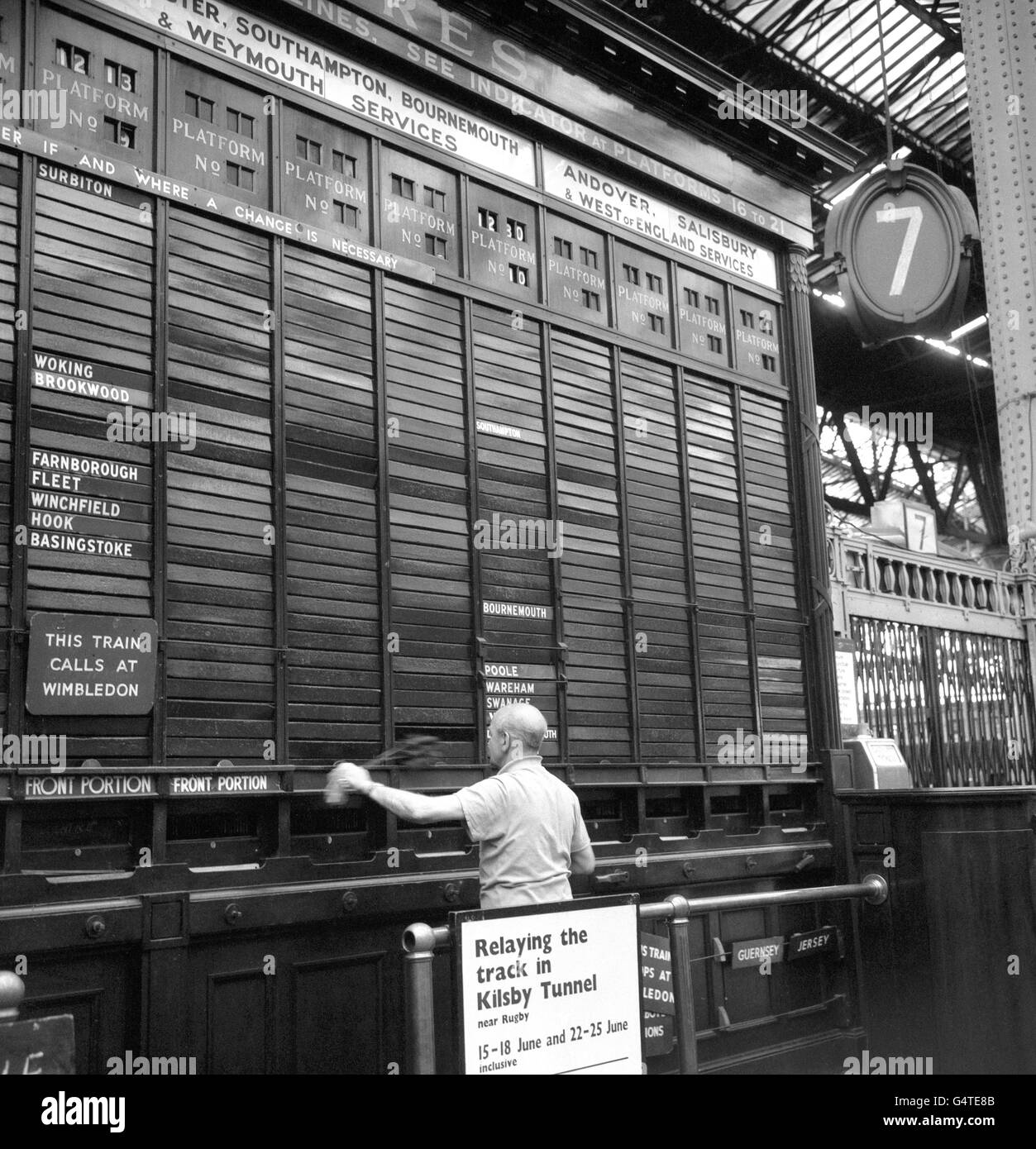Due to the current go-slow on the part of British Rail, a worker at Waterloo Station, London, finds it easy to clean the destination board Stock Photo