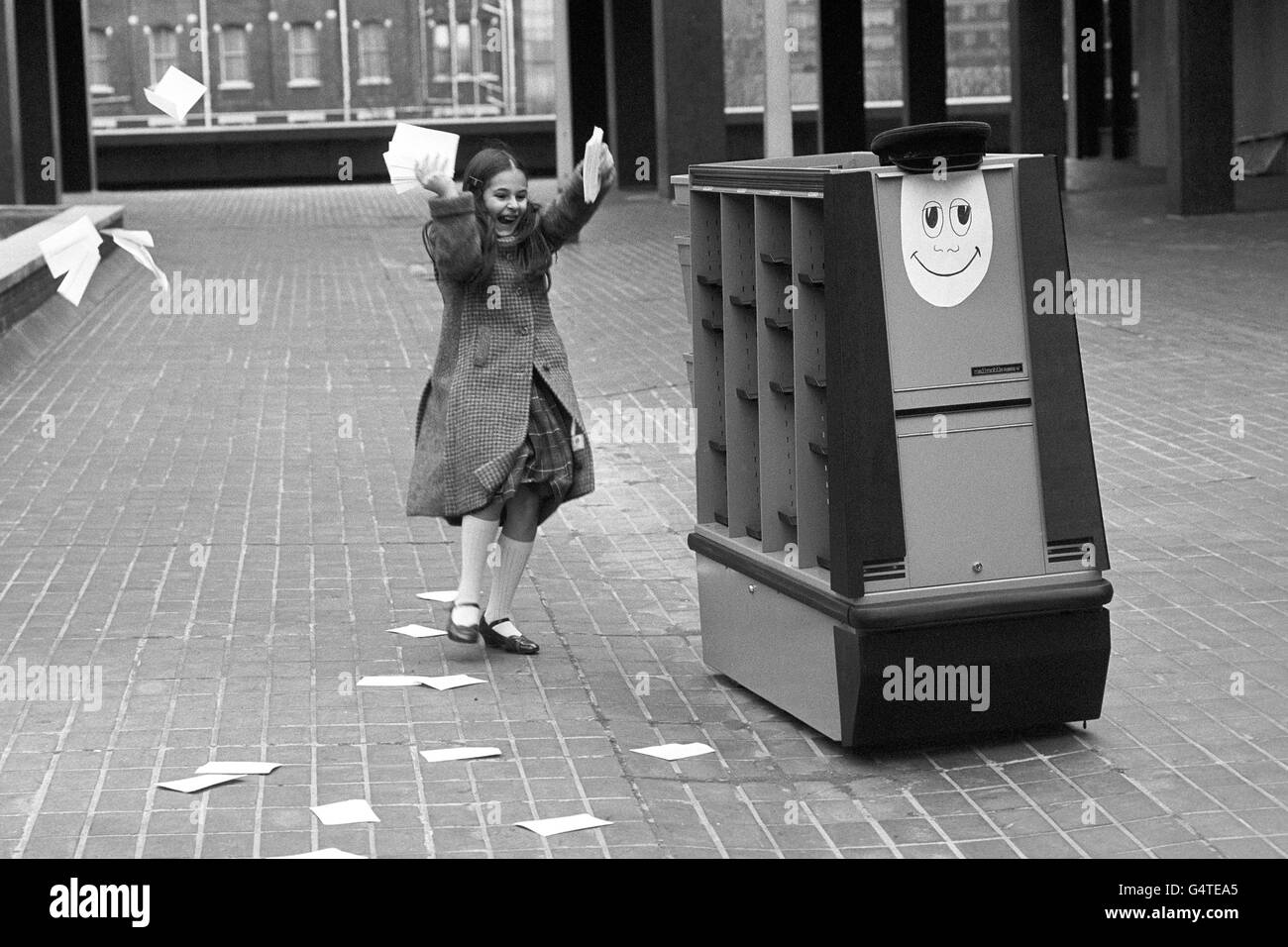 The world's first robot postman travels around the Cunard Hotel, West London, where the robot is to make its debut at the Info '81 exhibition. The smiling-faced robot has found a friend in 10-year-old Lisa Medalyer. Stock Photo