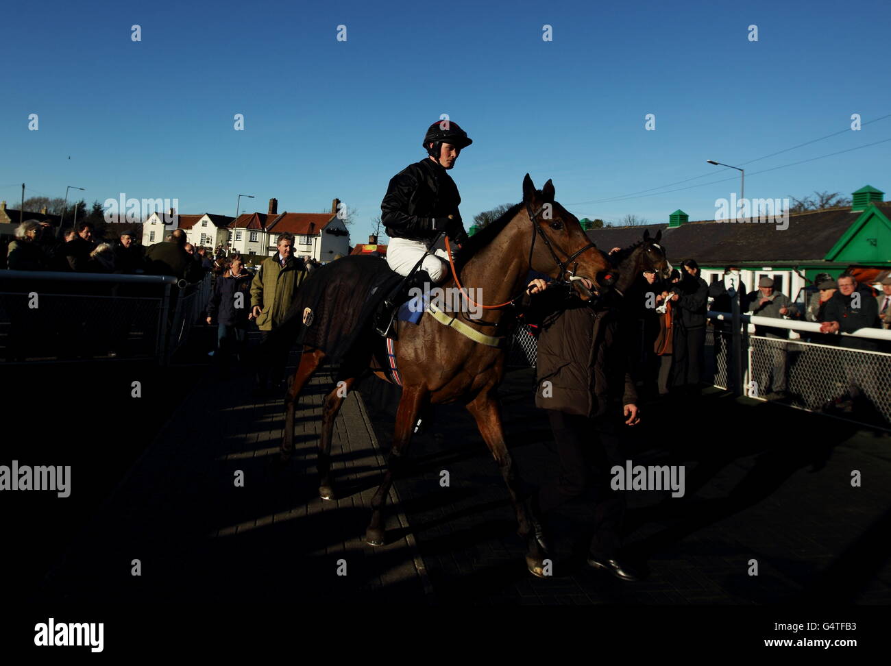 Jockey Jack Quinlan brings in Creekside to the winner's enclosure as trainer John Ferguson follows just behind Stock Photo