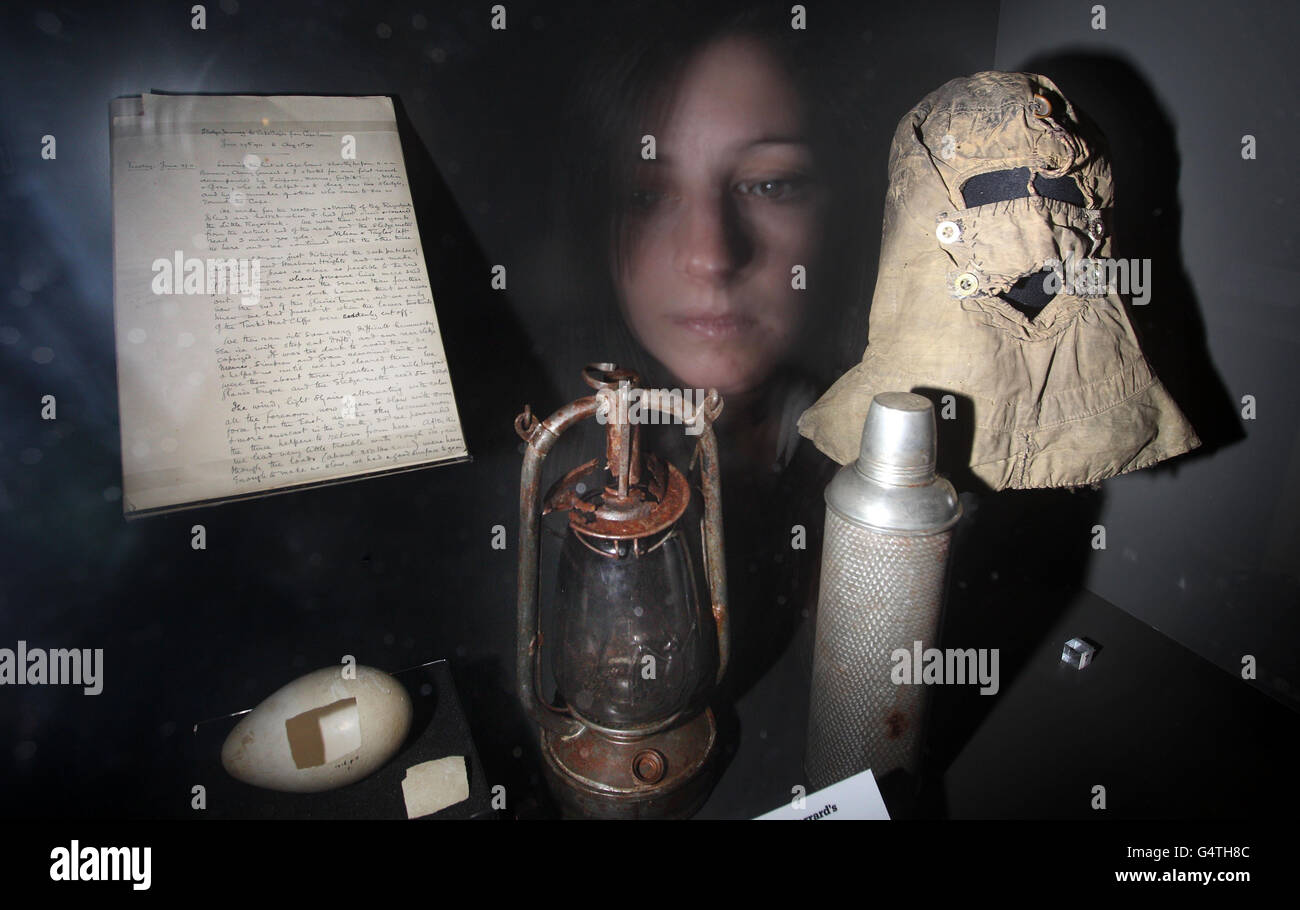 A woman looks at an exhibit, including an Emperor Penguin egg, Edward Wilson's account of the Winter Journey, a bat lamp from Cape Crozier, a Thermos Flask and Cherry-Garrard's balaclava that was used when collecting the Emperor Penguin eggs, at Scott's Last Expedition at the Natural History Museum, London. Stock Photo