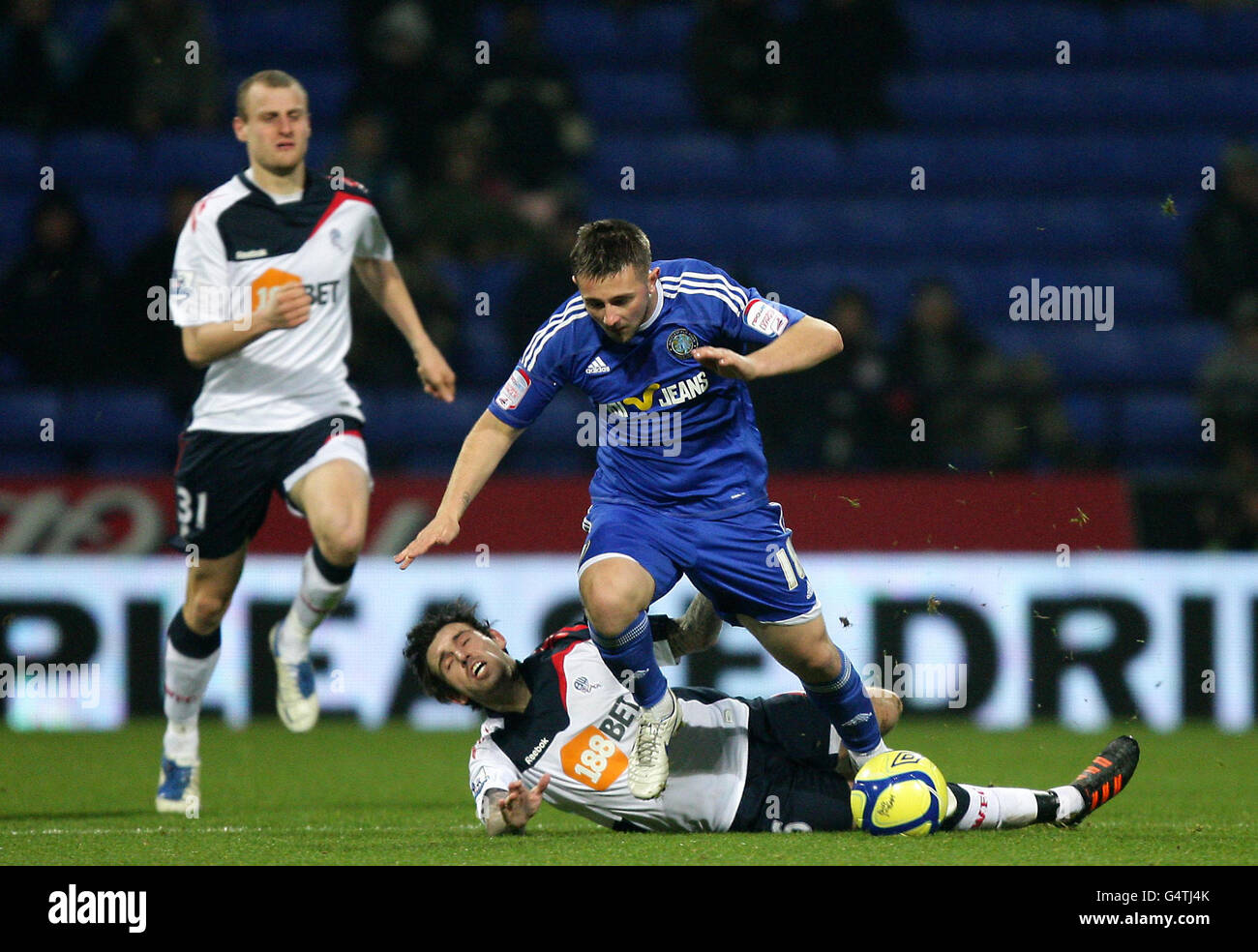 Bolton Wanderers' Mark Davis (floor) and Macclesfield Town's Waide Fairhurst battle for the ball during the FA Cup Third Round Replay at the Reebok Stadium, Bolton Stock Photo