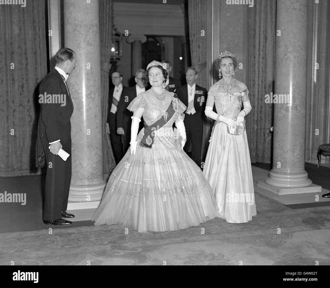Queen Ingrid of Denmark and Queen Elizabeth, with King George VI in the background, at a Government reception in Lancaster House, St. James's, London. The reception was the last function to be attended by King Frederik and Queen Ingrid during their State visit to Britain. Stock Photo