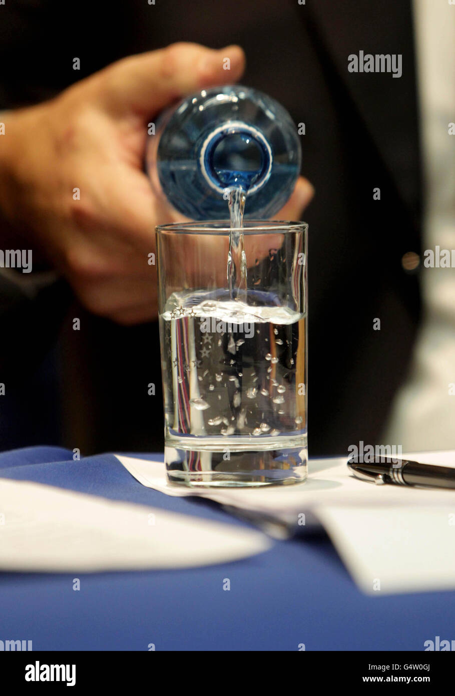 RETRANSMISSION AMENDING LOCATION. Istvan Szekely of the European Commission pours water into a glass with the EU logo on during a press conference on the progress of Irelands Fourth Quarter 2011 debt repayment at EU Commission headquarters in Dublin. Stock Photo