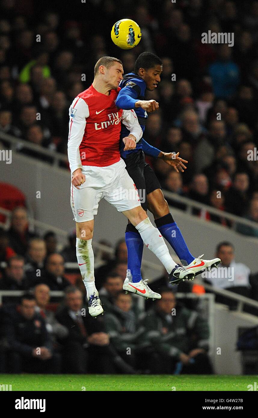 Manchester United's Antonio Valencia and Arsenal's Thomas Vermaelen (left) battle for the ball in the air Stock Photo