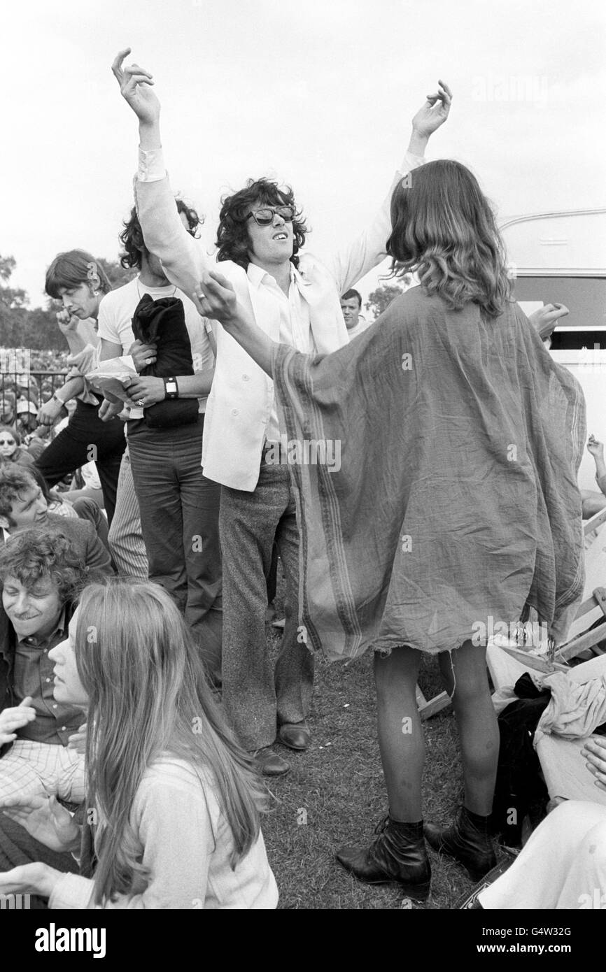 Letting their hair down at an open-air concert in London's Hyde Park are singer Donovan (in dark glasses) and an unnamed girl dressed in a sack, Stock Photo