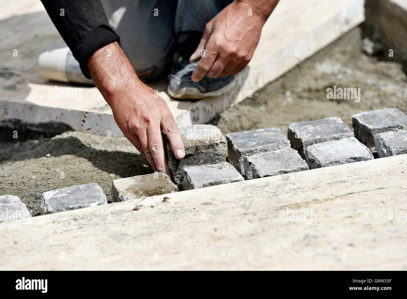 Details with hands of a mason working with cobblestone Stock Photo Alamy