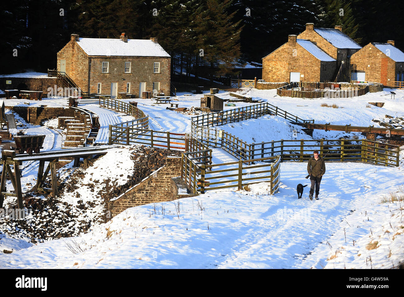 A man walks his dog through the snow at Kilhope, in County Durham as the country braced itself for a spell of cooler weather that has brought snow to some regions. Stock Photo