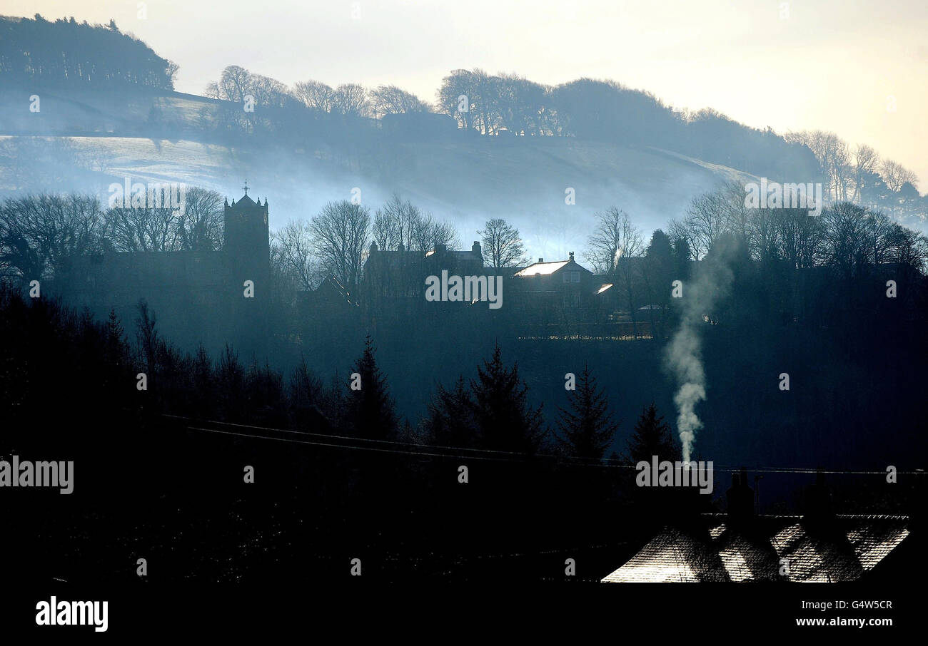Smoke from chimneys hover Allendale in Northumberland as forecasters warn the winter weather and freezing temperatures will affect the UK for several days to come. Stock Photo