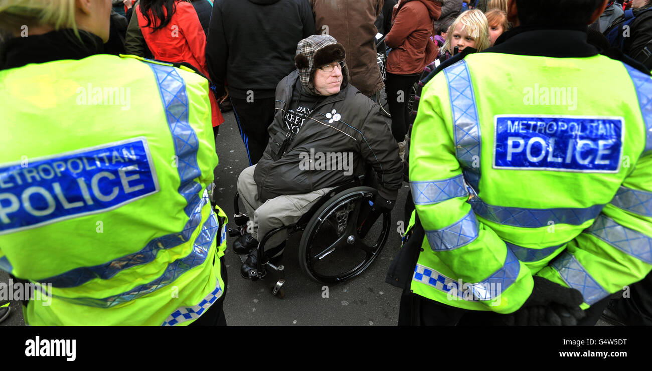A protestor (name not known) in a wheelchair and police during a demonstration in which a group of wheelchair bound protesters chained themselves together across Regent Street in Oxford Circus, London, as they protest against the Government's Welfare Reform Bill. PRESS ASSOCIATION Photo. Picture date: Saturday January 28, 2012. Members of direct action group UK Uncut and disability campaign groups chanted, waved banners and banged drums in the middle of Oxford Circus, blocking off its link with Regent Street. The groups are voicing their anger at the impact of the Welfare Reform Bill, warning Stock Photo