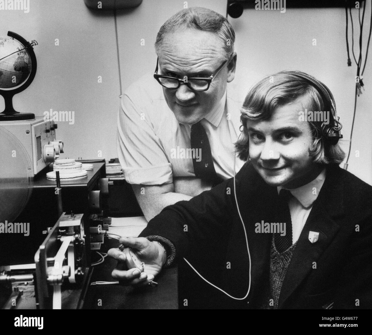David Muggleton, 16 year old member of Kettering Grammar School's space tracking team, listens in to signals from the Soviet Russian Soyuz spacecraft. With him is the team leader, Mr. Geoffrey Perry, physics master at the school. Stock Photo