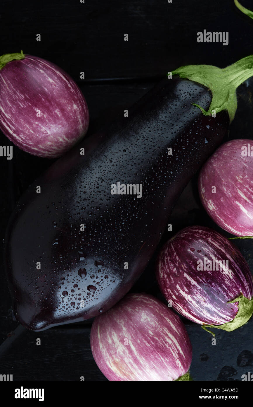 Wet black and purple striped eggplants extreme closeup. Top view, vertical image Stock Photo