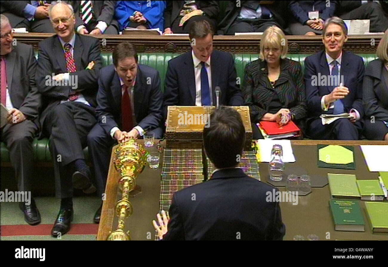 The Coalition front bench react as Labour party leader Ed Miliband (bottom) speaks during Prime Minister's Questions in the House of Commons, London. Stock Photo