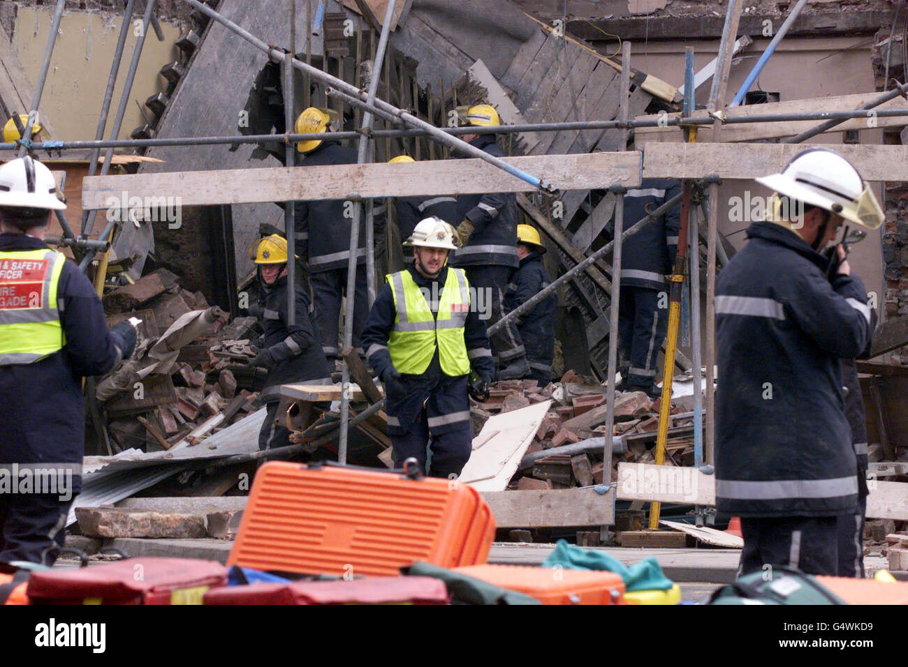 Firefighters search through the rubble of a collapsed building in ...