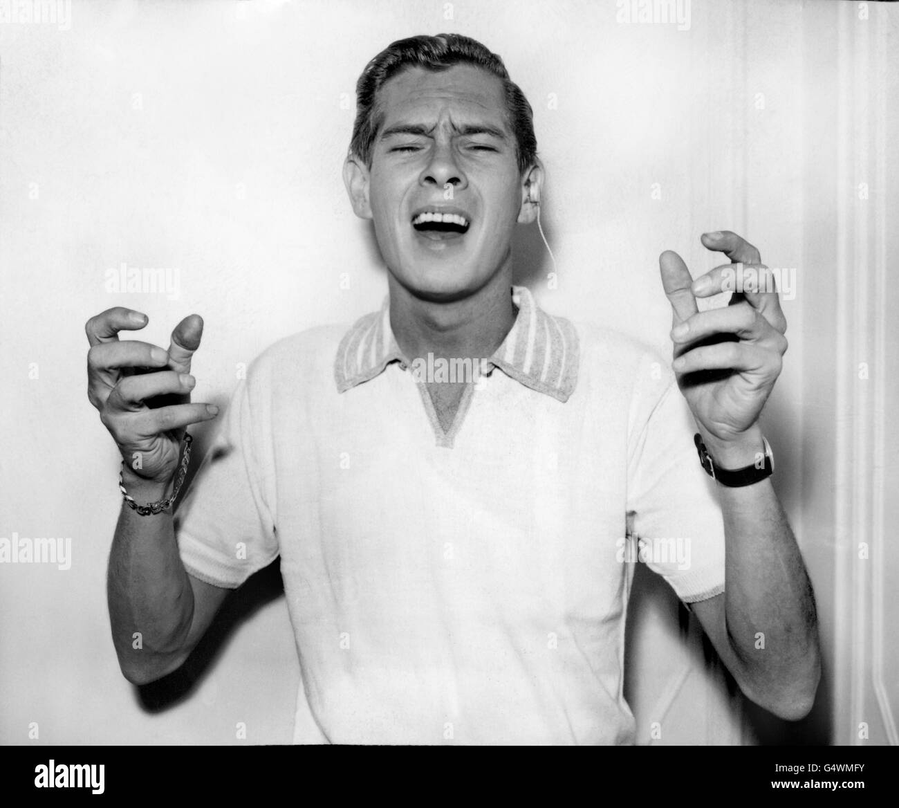 Johnnie Ray entertains fans at a reception in a London hotel to celebrate his arrival from New York. Ray flew in to star in the commercial television show 'Sunday Night at the London Palladium'. Crash barriers and extra police were needed to control the crowds of screaming girls. Stock Photo