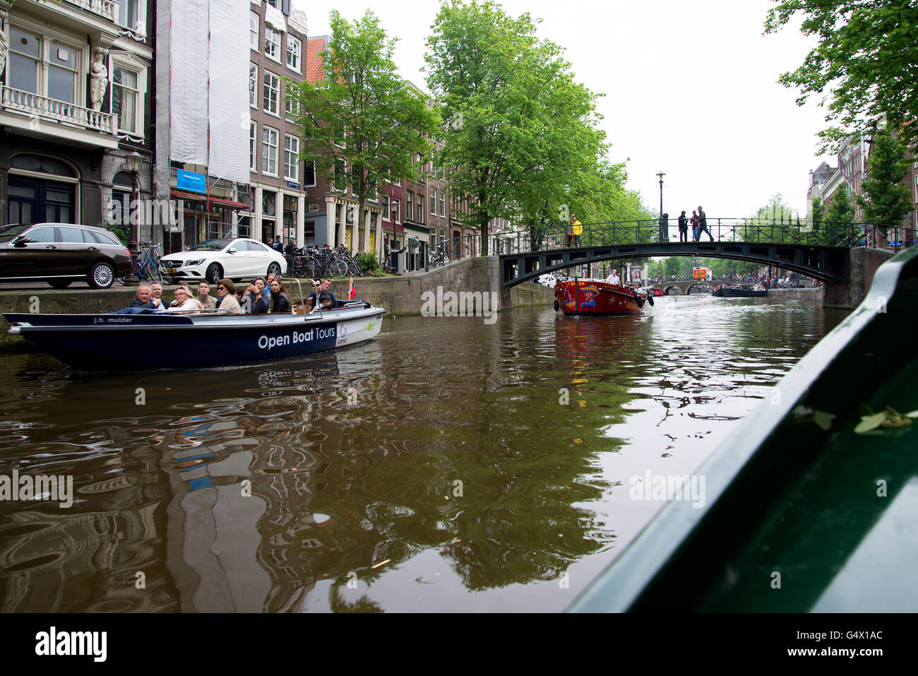 Amsterdam city center bridge people walk walking cross crossing over canal. Stock Photo