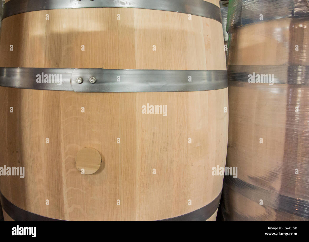 New Barrel and Wrapped Barrel before being filled at a bourbon distillery Stock Photo