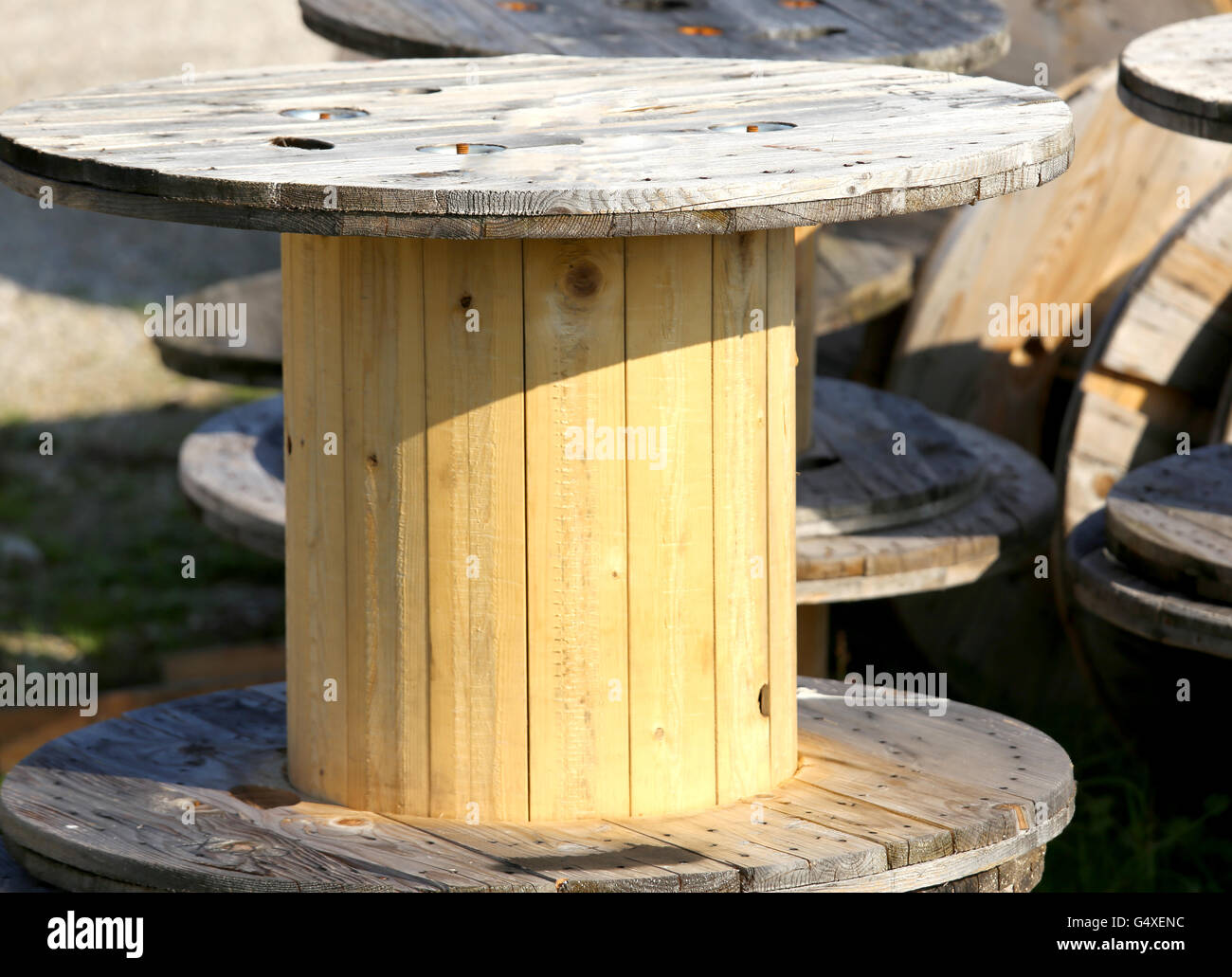 big wooden spools of electric cables in a landfill of recyclable