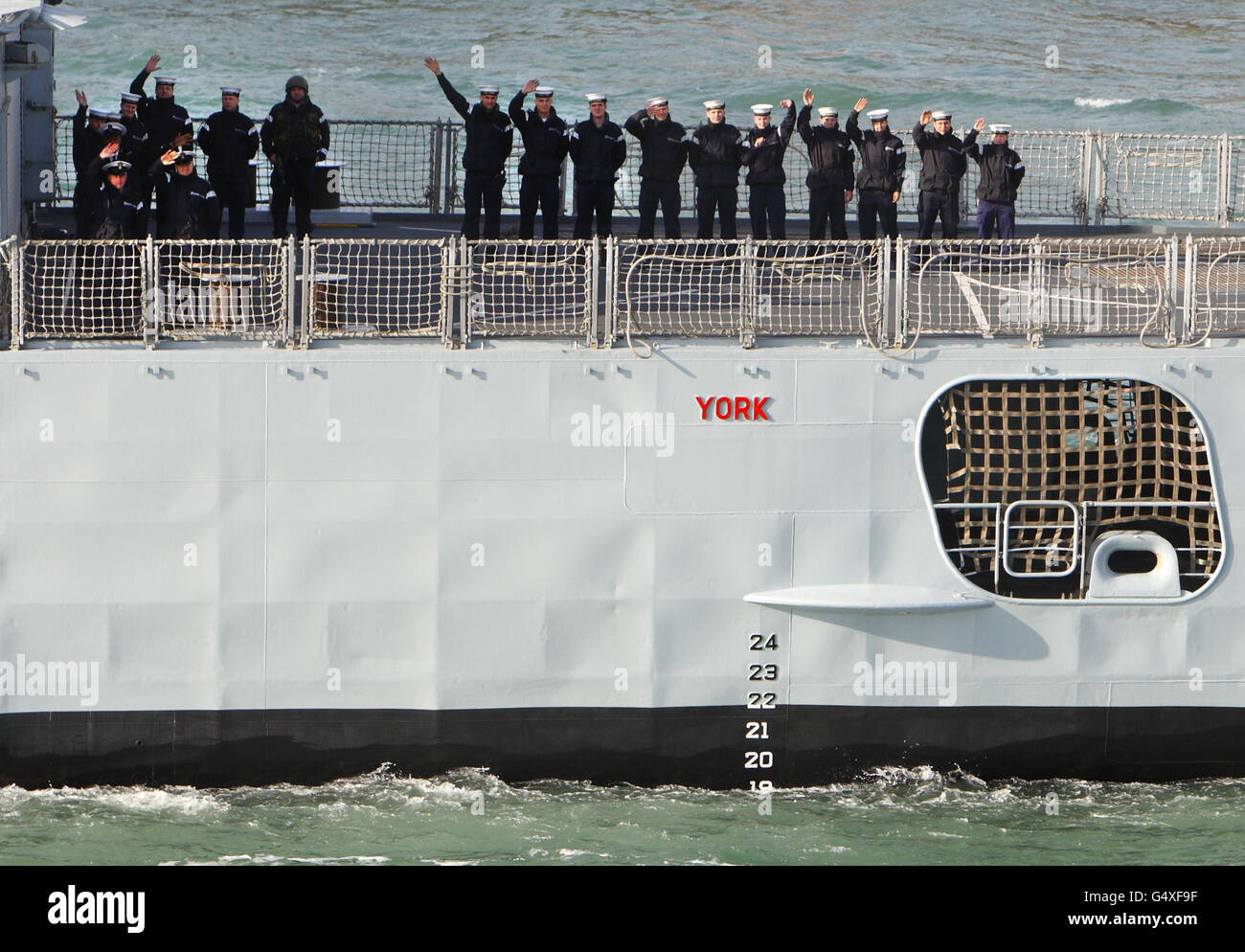 Sailors aboard HMS York wave to family members and loved ones on shore ...