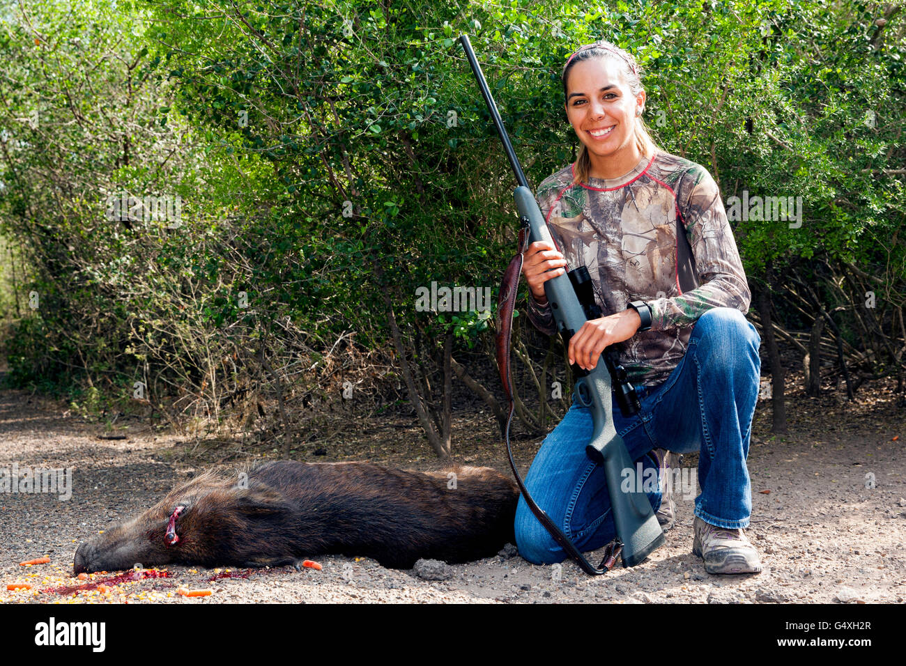 Young woman hunter with feral hog kill - Brownsville, Texas, USA Stock Photo