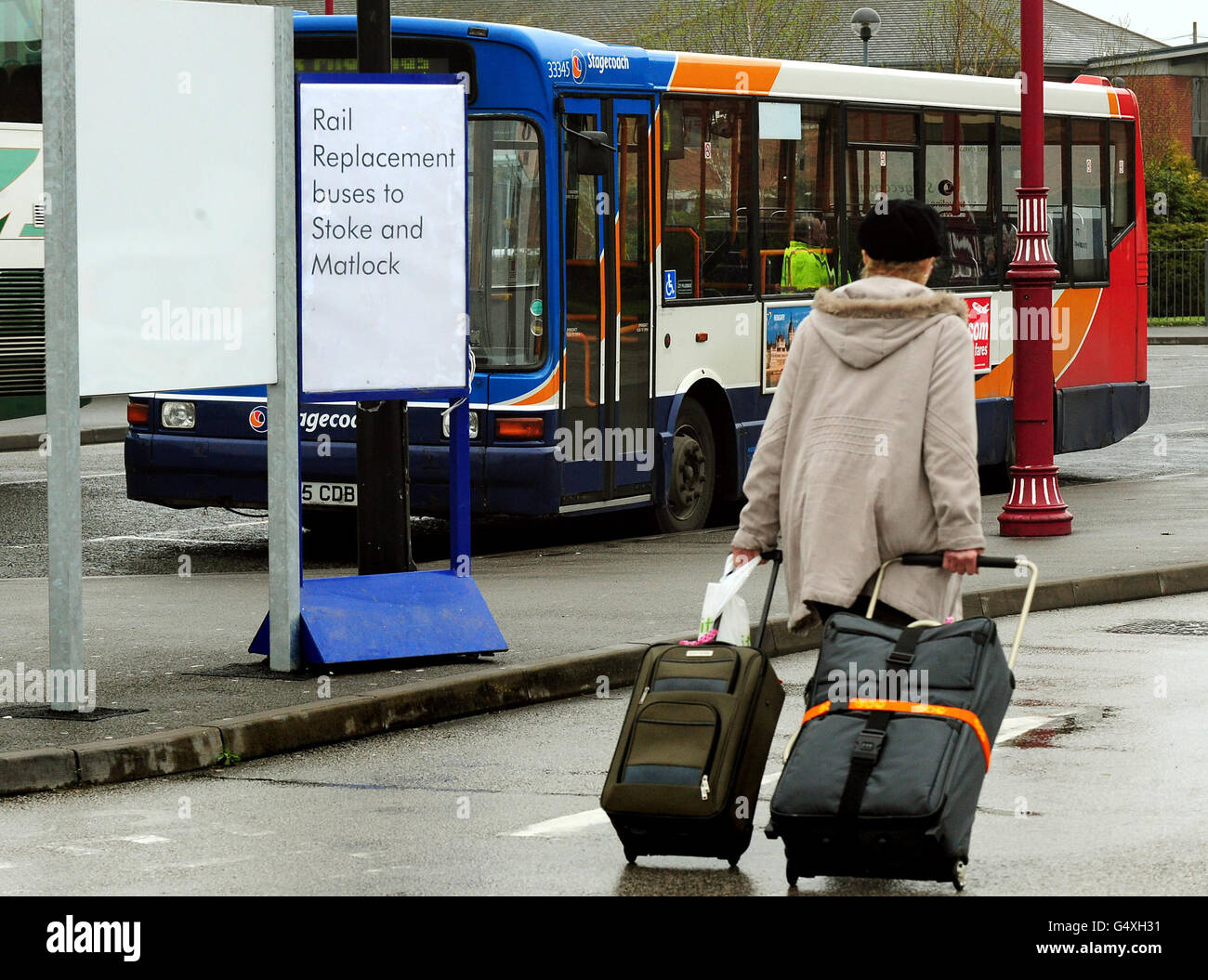 Passengers use bus transfers at Derby Train station as members of the