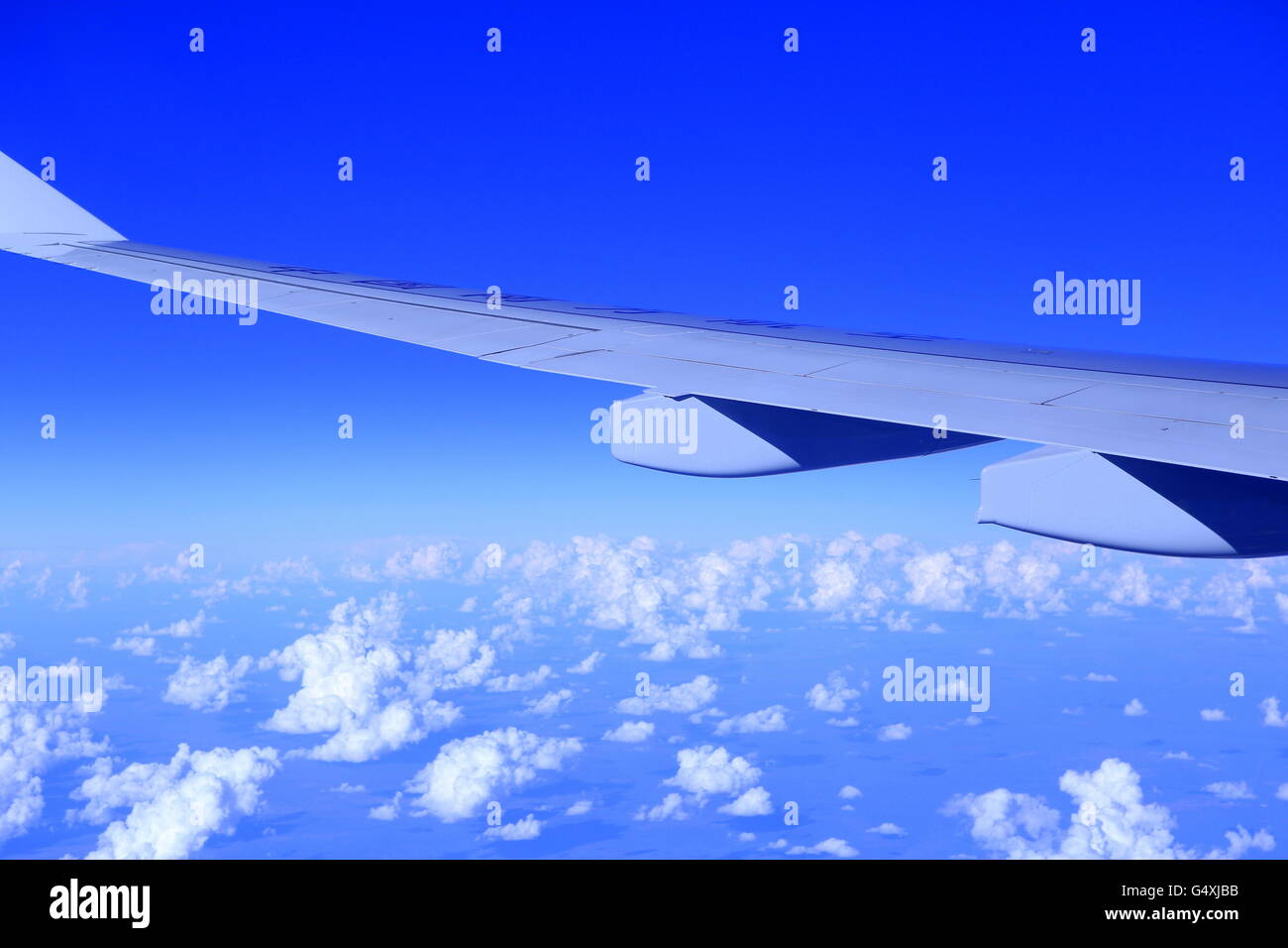 picture of an airplane wing in the blue sky above white clouds Stock ...