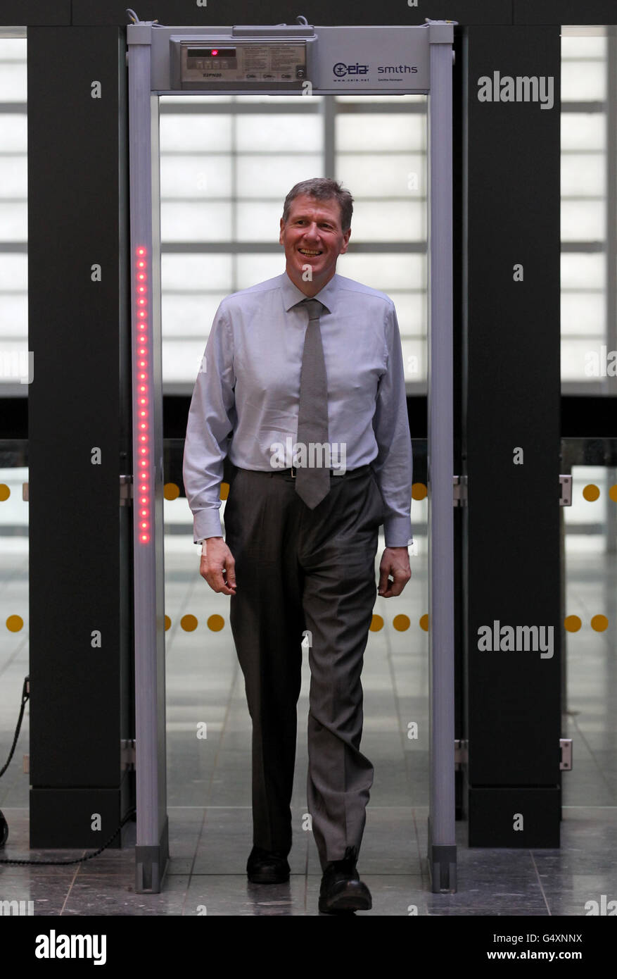 Justice Secretary Kenny MacAskill walks through a security barrier as he travels airside during a visit to Glasgow airport where he met police and toured the airport security operation and to hear about positive measures taken by the police to address concerns about the use of Schedule 7 powers. Stock Photo