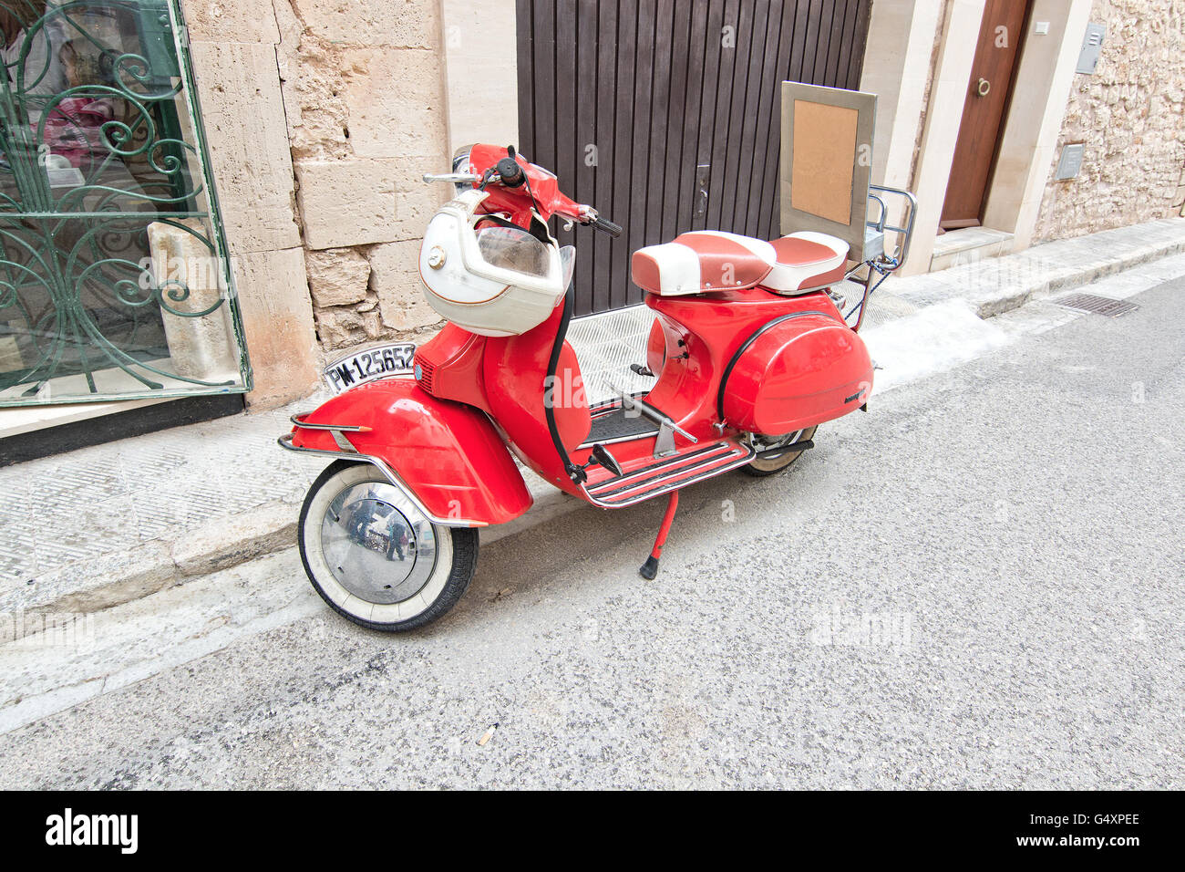 Red beautiful vintage vespa with helmet parked in the street in Santanyi,  Mallorca, Balearic islands, Spain on April 30, 2016 Stock Photo - Alamy
