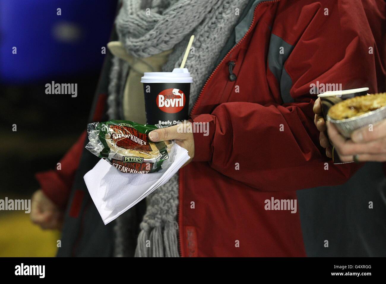 Fans warm up in the cold weather with a half time pie and drink of bovril Stock Photo