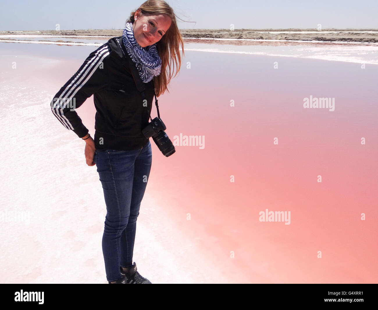 Namibia, Erongo, Walvis Bay, Dorob National Park, Woman in front of red saline water Stock Photo