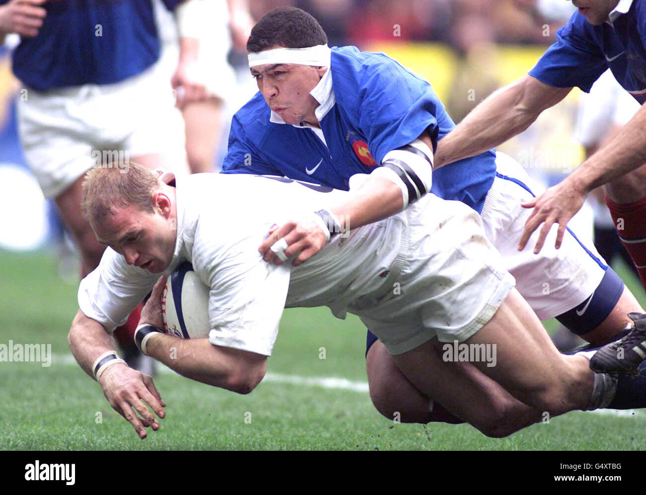 England's Lawrence Dallaglio is brought down by Frenchman Abdelatif Benazzi (blue) duirng the France v England Six Nations rugby match. Stock Photo