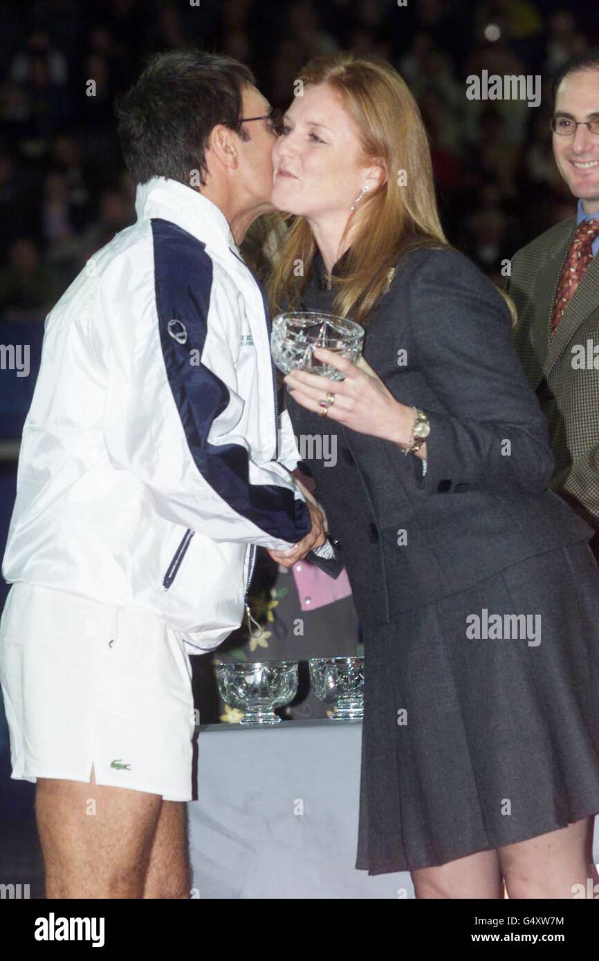 Singer Sir Cliff Richard gives the Duchess of York, Sarah Ferguson, a kiss on the cheek as she awards the team captain the trophy for winning the celebrity charity tennis tournament, the York Charity cup, at the London Arena, Docklands. * is in aid of raising money for the charity Children in Crisis. Stock Photo