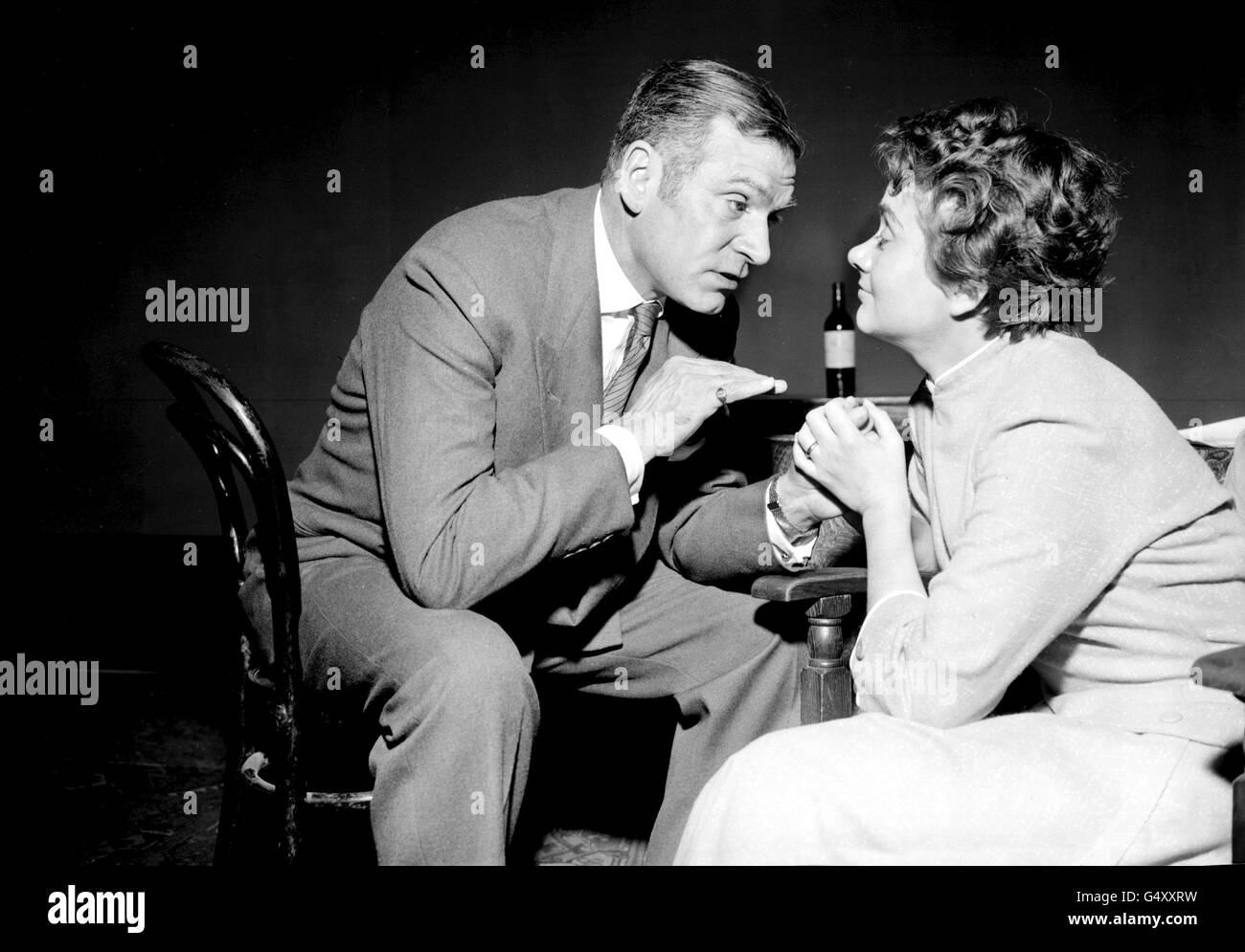 PA NEWS PHOTO 1957: Slightly tipsy - he's at the reminiscing stage - is Archie Rice, played by Sir Laurence Olivier. The attentive listener is his daughter, Jean, played by Joan Plowright (26). They are pictured at the Palace theatre rehearsing for 'The Entertainer'. Stock Photo