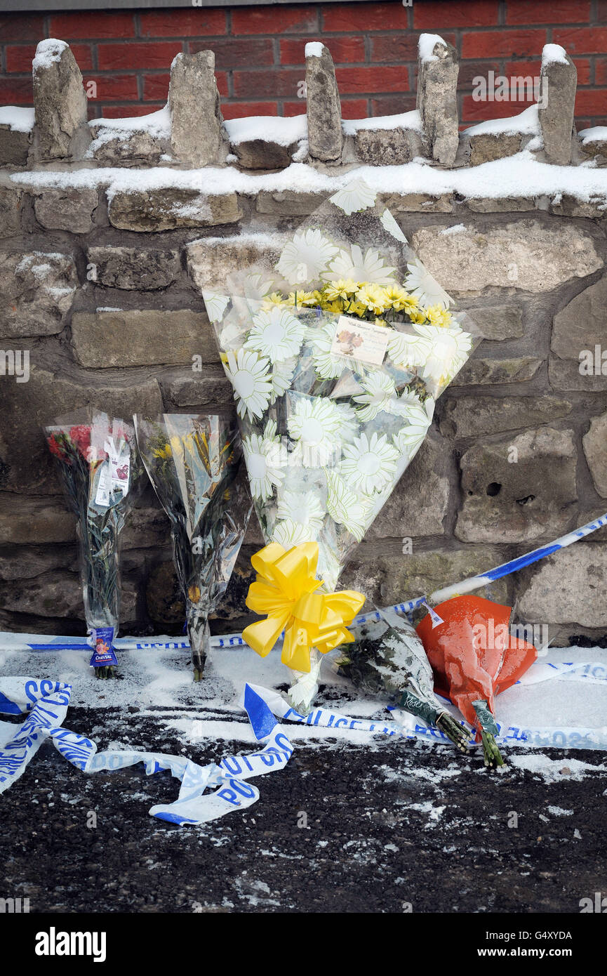 Floral tributes at the scene outside an address on Woodgate Road in the