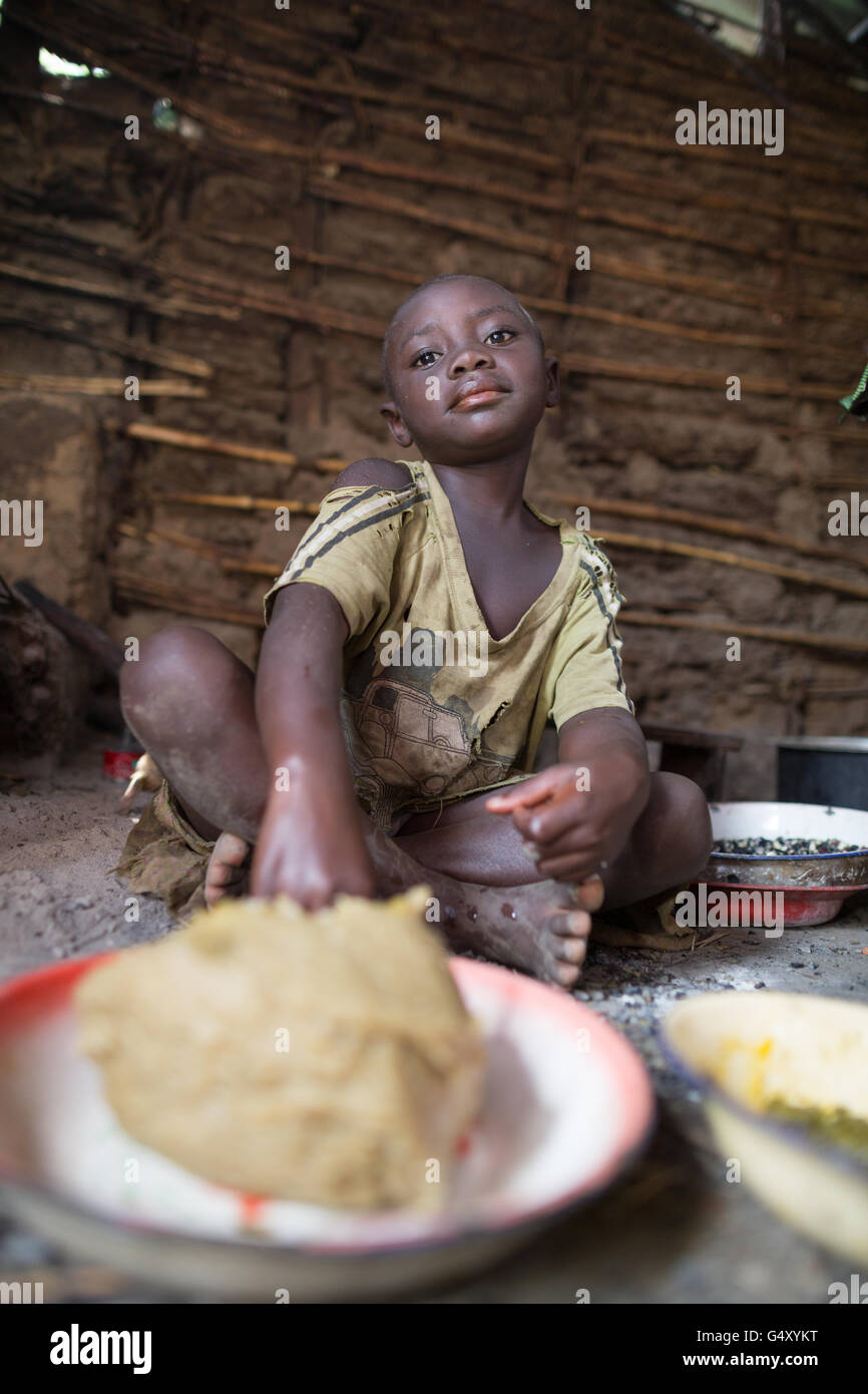 A child eats a meal in her family’s kitchen in Kasese District, Uganda. Stock Photo