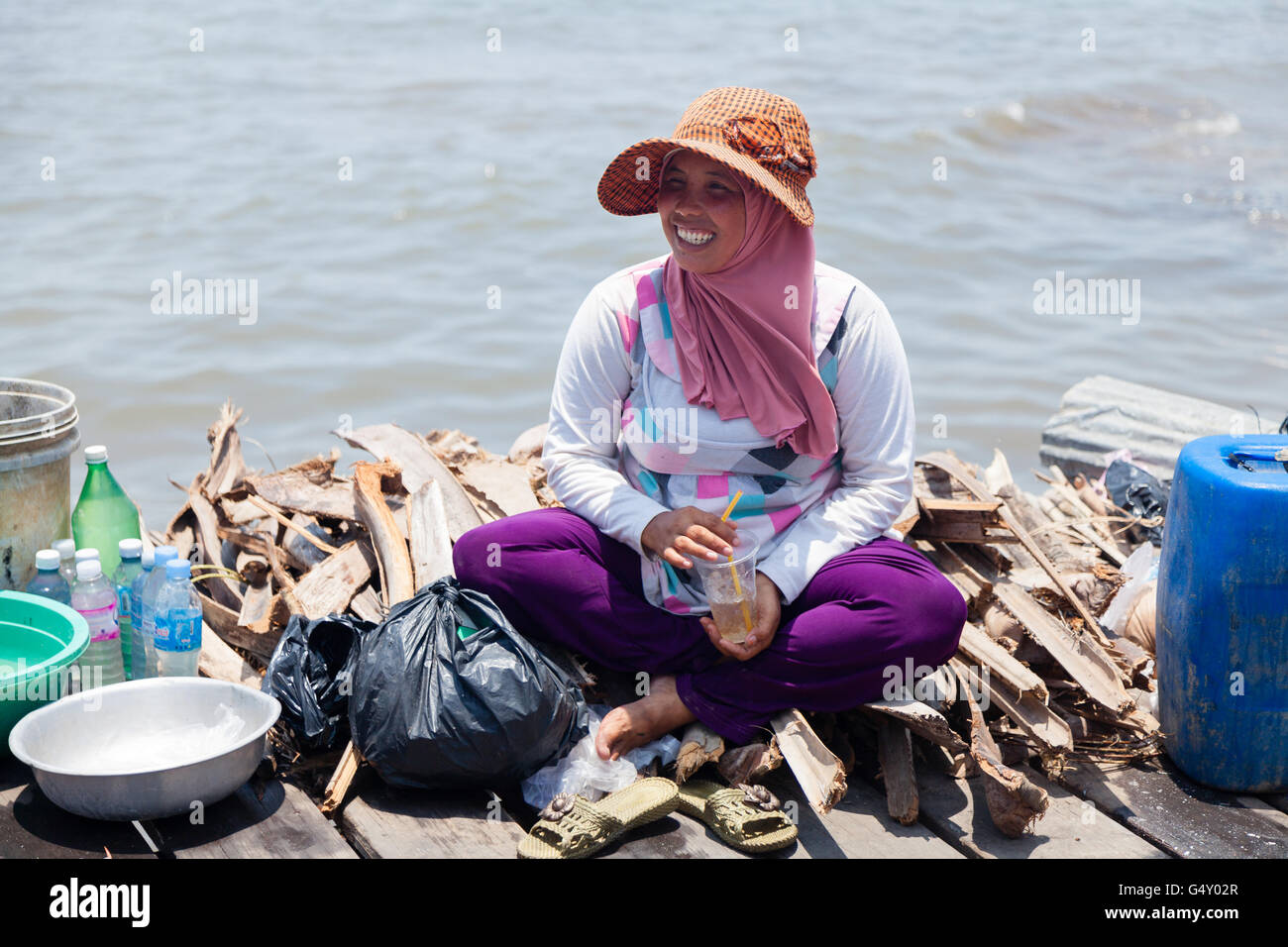 Cambodia, Kep, crabs market, woman sitting laughing at firewood at the crabs market Stock Photo