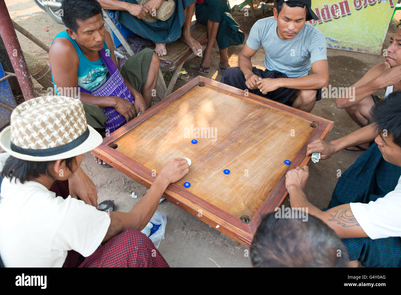 Local men playing carrom (karrom) board game, Old bagan archaelogical zone, Mandalay Region, Myanmar Stock Photo