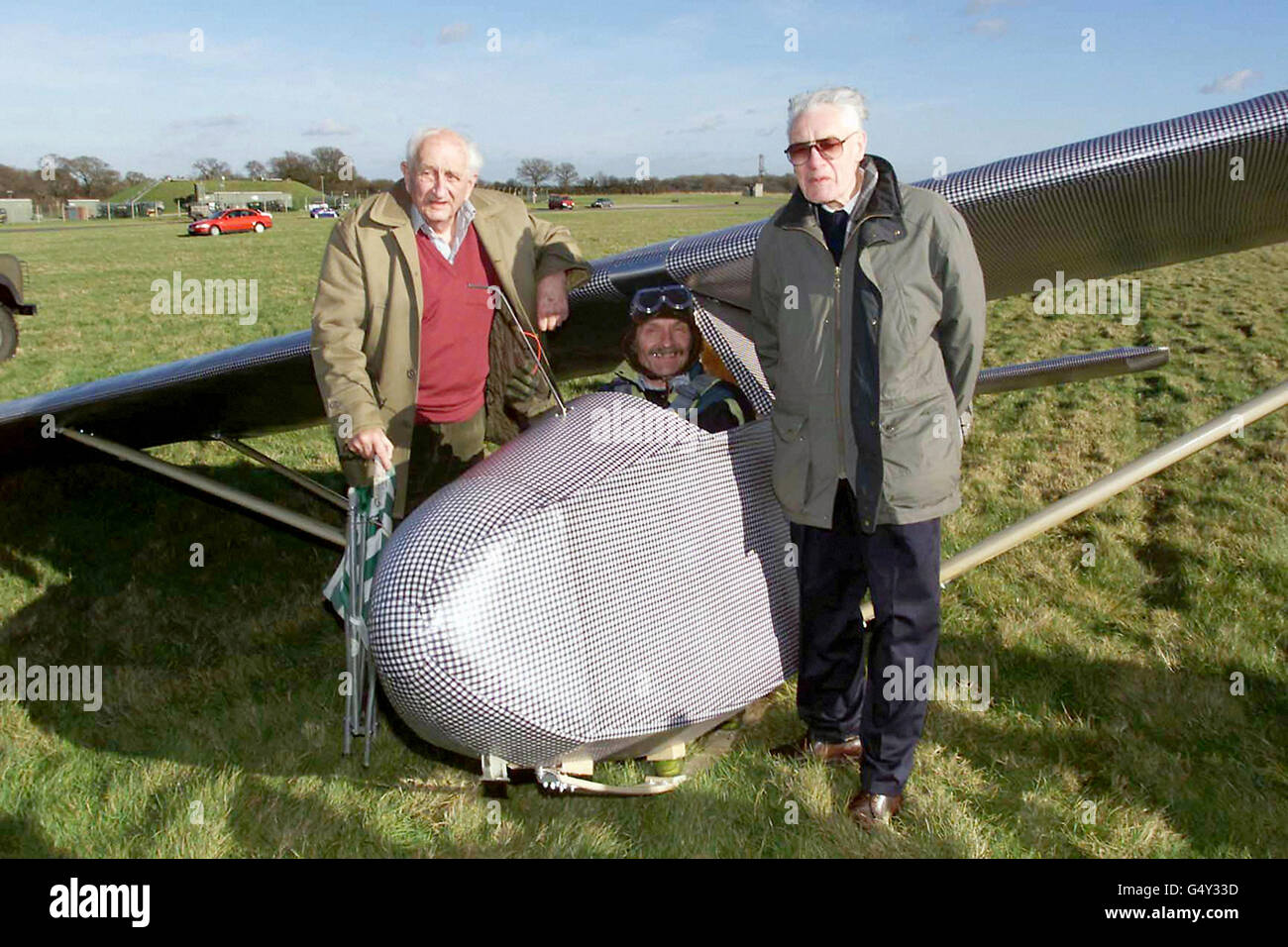 Veterans of the infamous Colditz camp, Jack Best (left)and Bill Goldfinch (right) with a replica of the glider they built in the prison, flown at RAF Odiham in Hampshire by pilot John Lee (centre). The original was made in secret at the prison, but was never flown. Stock Photo