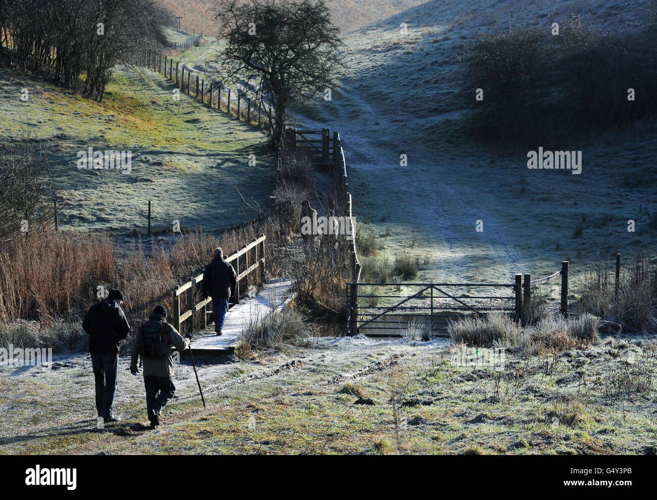Walkers make their way over the frozen ground in Millington Pastures