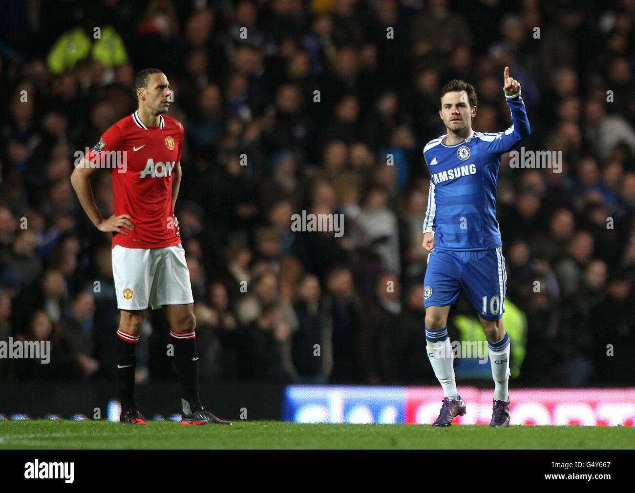 Chelsea's Juan Mata (right) celebrates after scoring his side's second goal of the game, as Manchester United's Rio Ferdinand stands dejected Stock Photo