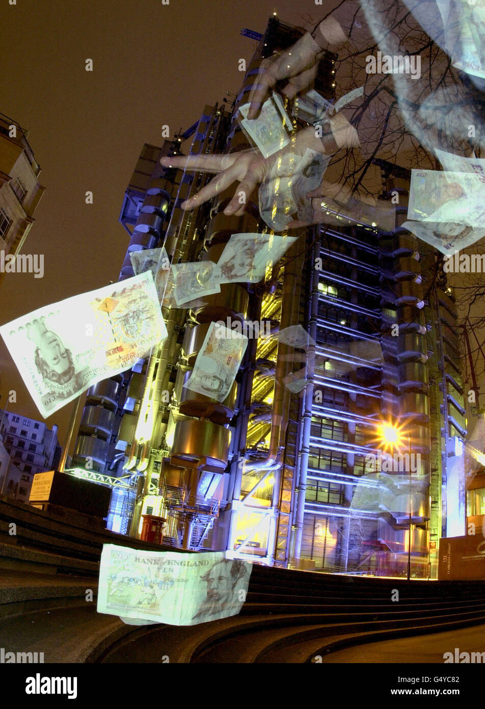 Bank notes fluttering in front of the Lloyds insurance market building in the City of London, taken 27/02/2000 evening, as Lloyds Names prepare to go to the High Court, London, claiming they were victims of a massive fraud in the 1980's. * The photographic effect is achieved by shooting the bank notes with multiple flash. Stock Photo