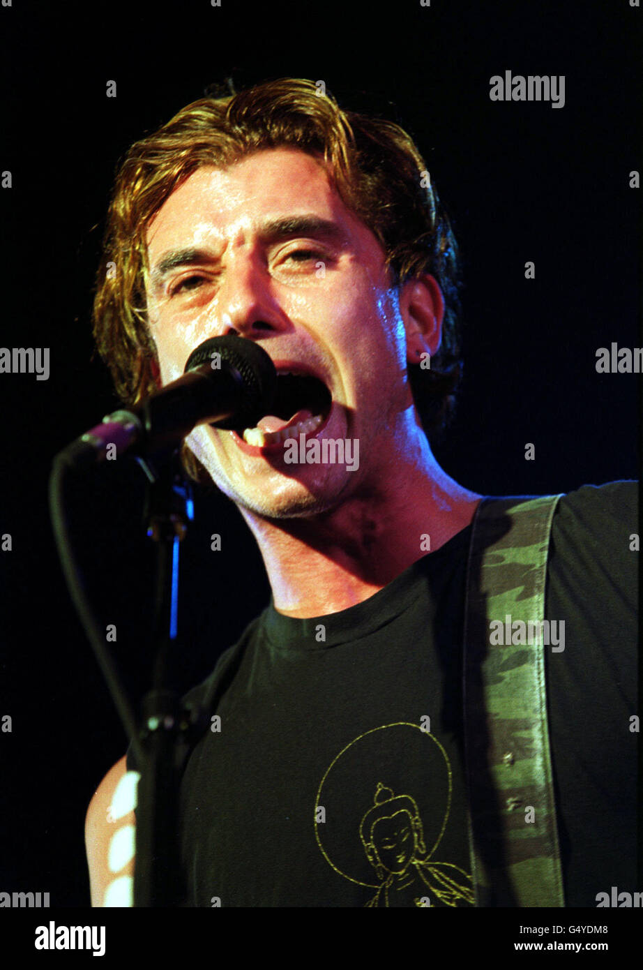 Music celebrity mouth open singing into microphone guitar strap hires